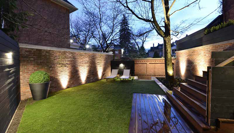 Modern backyard transformation featuring low-maintenance artificial grass and the multi-level deck structure, maximizing the smaller urban space.