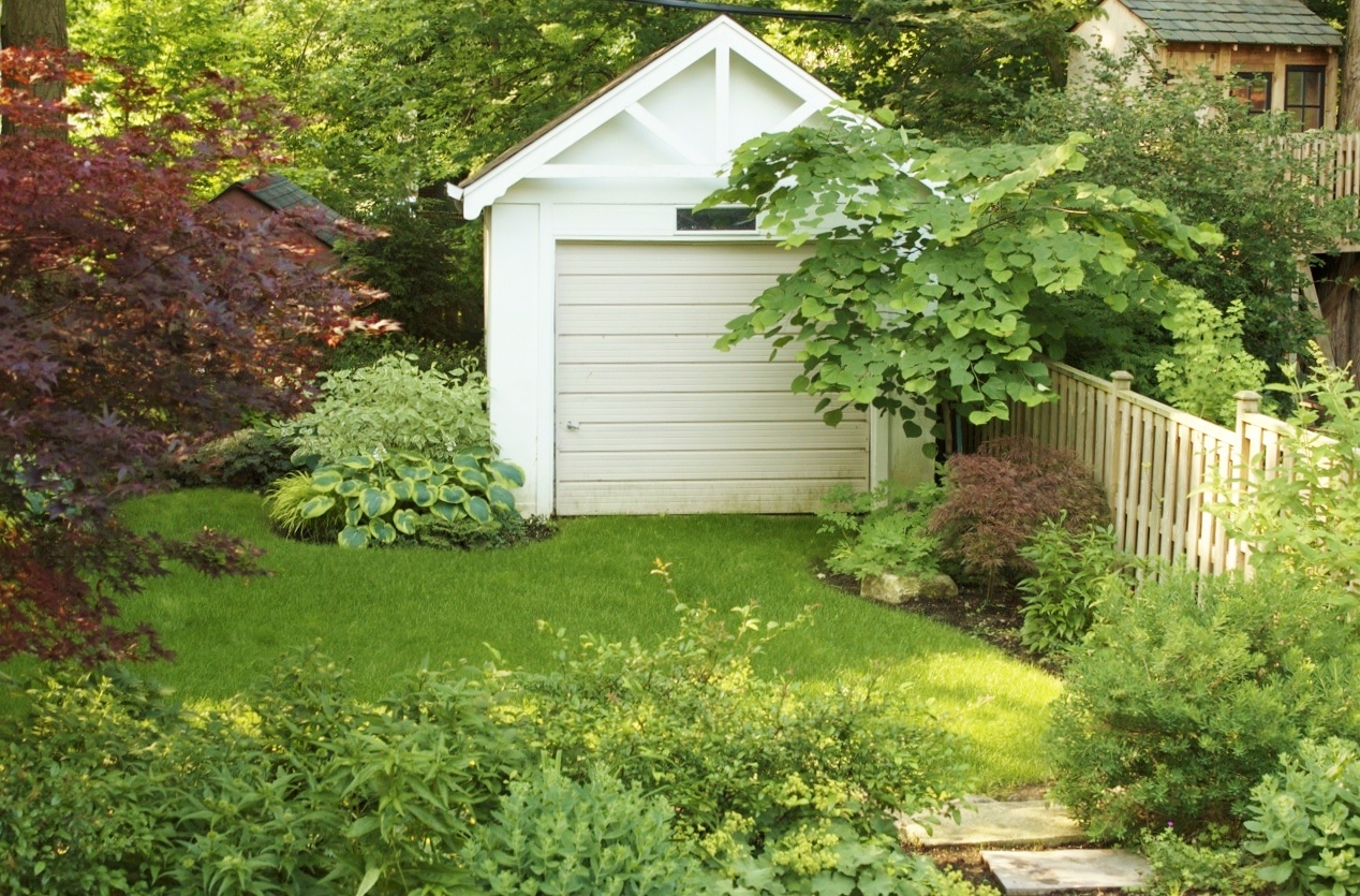 Shed surrounded by perennial garden beds