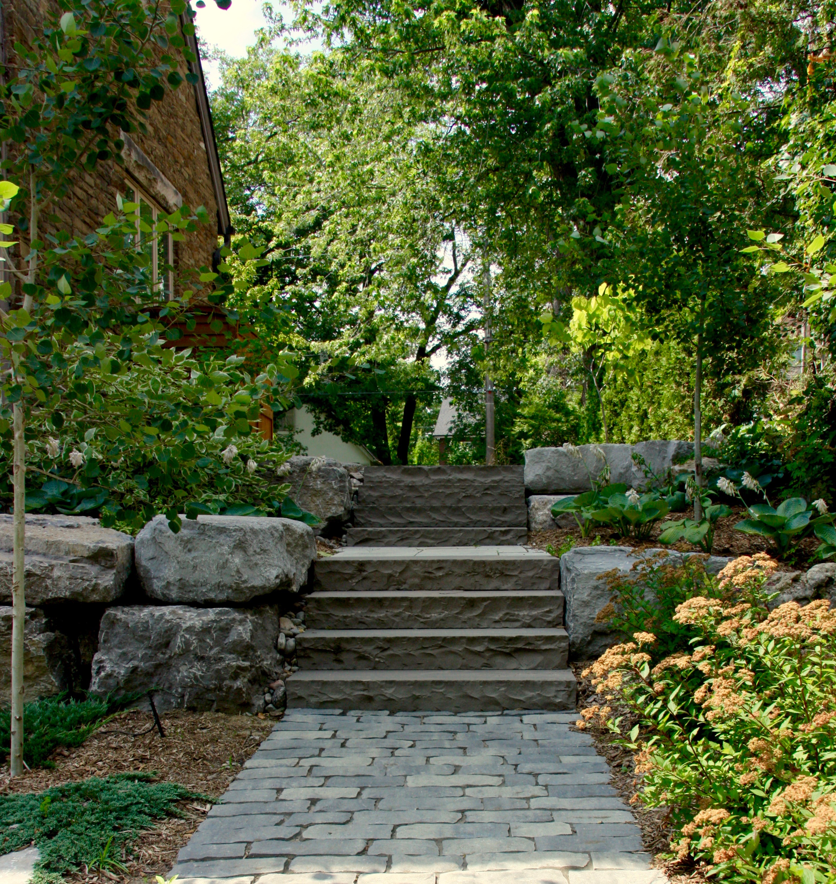 stone steps leading up from backyard to front of the house. Custom Built