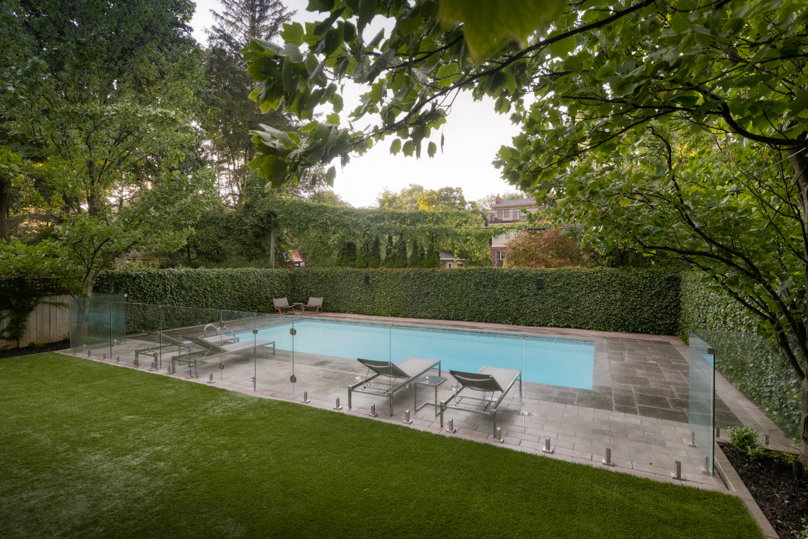 Astro Turf backyard enclosed with tall standing hedges
