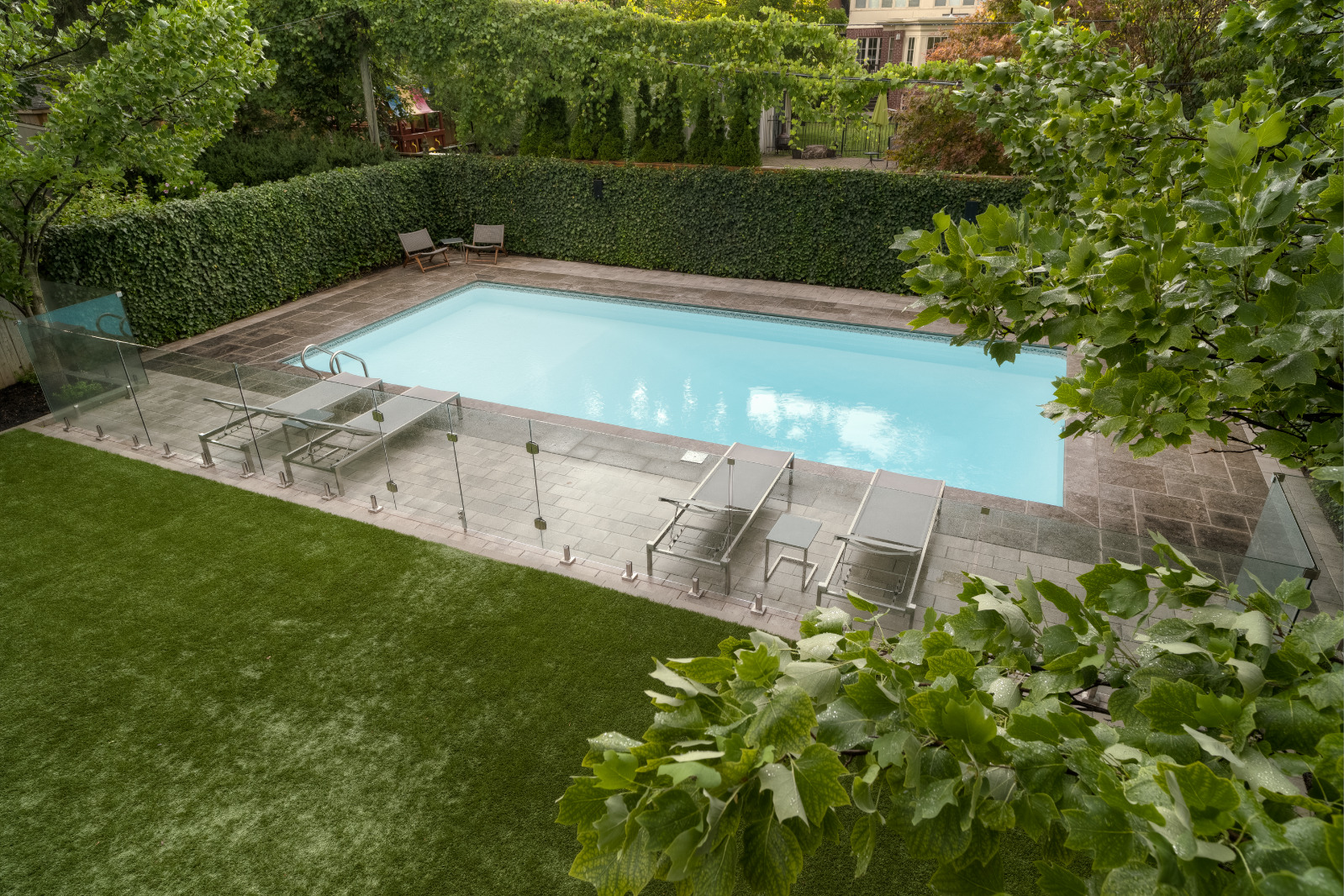 Artifical turf with stone and glass enclosed pool